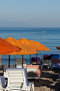 海滩休息员和海边的雨伞假期海洋休息情调晴天椅子海岸旅游支撑火鸡图片