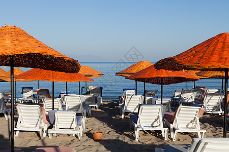 海滩休息员和海边的雨伞晴天情调海岸假期太阳异国橙子海景旅游天空图片