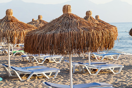 海滩休息员和海边的雨伞假期橙子支撑椅子情调晴天热带闲暇海景溶胶图片