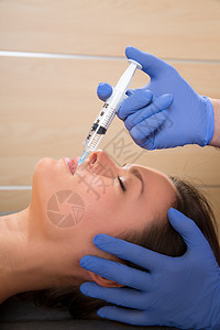女性脸上的抗老化面部治疗针筒手术注射器女士皮肤化妆品蓝色外科女孩病人嘴唇图片