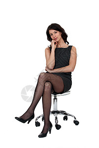 坐在椅子上的妇女头发弯头黑发手臂迷你裙高跟鞋折叠下巴黑色裙子图片