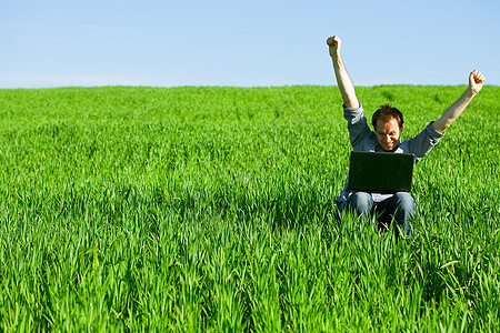年轻人在户外使用笔记本电脑风景太阳人士商务草地寂寞商业互联网自由天空图片