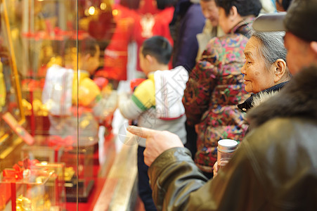 一个女人站着看金店的窗子图片