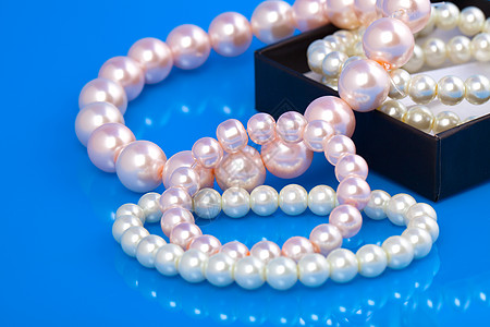 蓝底的珍珠项链细绳展示石头宝石蓝色礼物珠宝宏观奢华图片