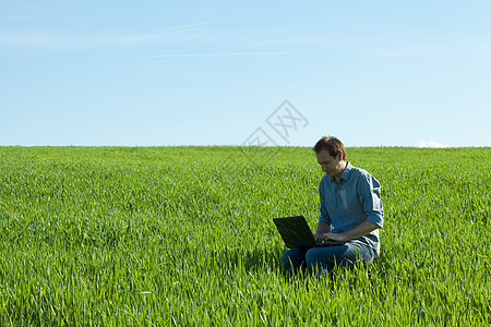 外地使用笔记本电脑的青年男子沉思天空城市地平线商务场景寂寞全景风景太阳图片