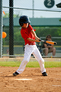 青年棒球运动员挥棒球棒图片