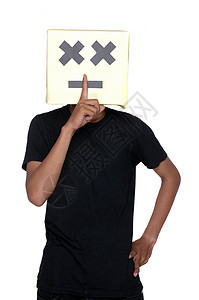 年轻男孩用纸板盒在脸上指着手指 做一个沉默的标志图片