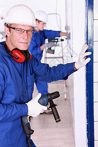 人钻探男性倾斜石匠专家边员工作服眼镜蓝色技术员男人图片