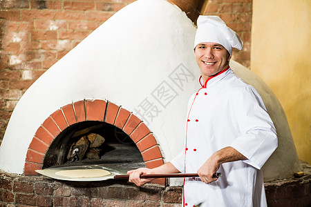 厨师在烤箱里放钱做披萨烹饪食堂面包员工柜台厨房款待木板餐厅壁炉图片