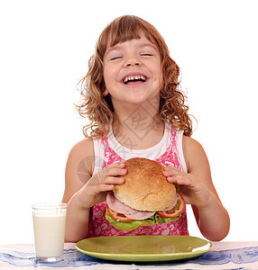 快乐的小女孩吃大三明治早餐时间图片