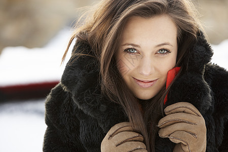 在雪地风景中近身穿羊毛衣的少女毛皮帽子女性微笑青少年寒冷下雪花园笑声场景背景图片