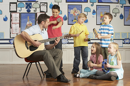 男教师与有C级音乐课学生一起玩吉他图片