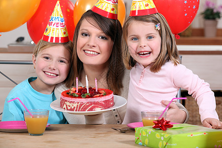 孩子的生日椅子纪念日蜡烛帽子姿势庆典蛋糕桌子菜肴母亲图片