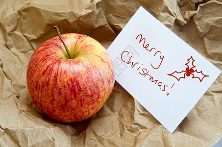 写在棕纸上的圣诞苹果礼物图片