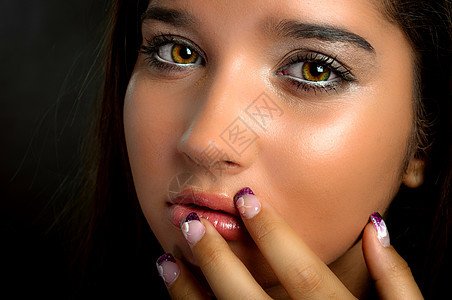 年轻模特用手指抚摸她的脸眼睛羽毛女孩眼皮皮肤睫毛女士照片奢华温泉图片