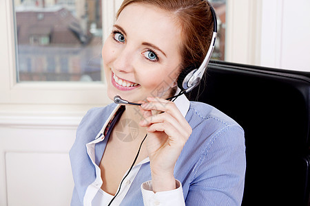 微笑着的年轻女性呼叫中心 带着耳盔的代理电话调度员服务台成人电脑操作员人士讲话商业工人图片