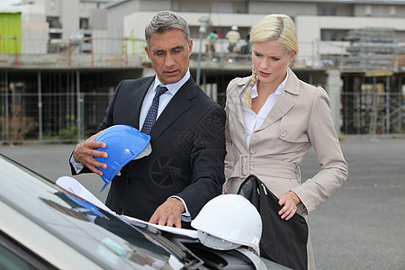 男建筑师和女建筑师站在汽车旁图片