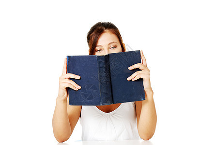 女孩阅读和躲在书后面学习文学女性女孩们眼睛头发图书黑发知识裙子图片