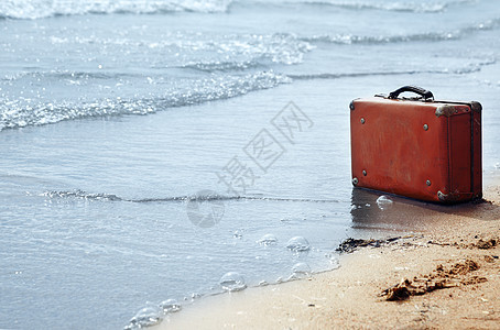 孤单在沙滩上手提箱橙子手提包寂寞孤独旅行支撑旅游海洋创造力图片