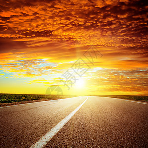 沥青路上空的红色急剧夕阳国家太阳晴天日落天气驾驶路线天空旅行小路图片