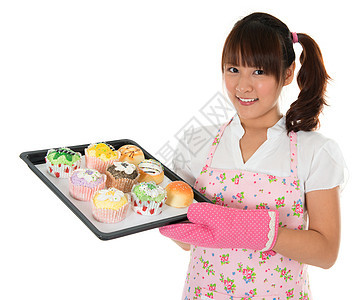 亚洲年轻女孩烤面包和纸杯蛋糕图片