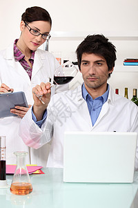 在实验室检测葡萄酒的男男女女厘米工具餐具液体实验者化学家生物学控制分米质量图片