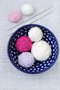 盘子上闪亮的毛线和编织针头球灰色桌布粉色星星喜悦消遣紫色白色线圈站立图片