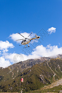 运输直升机飞越山区荒野上空飞行转子尾巴货物风景空运飞机工作航空山脉航班背景图片
