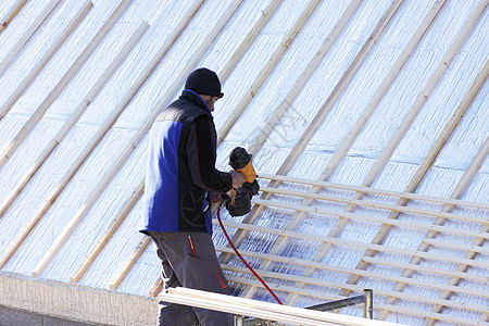 屋顶在木柴新屋顶上工作木匠木工建设房子工人安全男性卵石屋主承包商图片