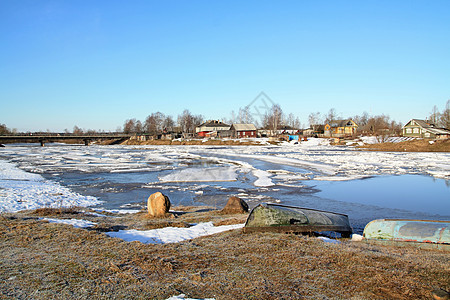 在靠近村庄的河流上驱冰房子建筑小屋季节天气蓝色乡村风景天空场景图片