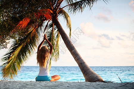 棕榈下的瑜伽妇女冥想海滩旅行海岸温泉训练蓝色闲暇女孩天堂图片