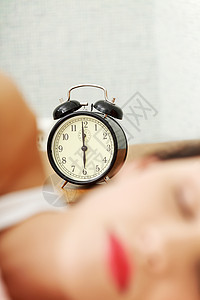 睡着的女人 在背景中有一个闹钟图片