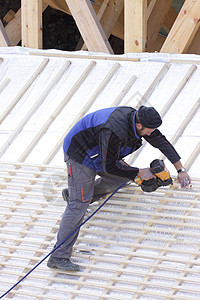 屋顶在木柴新屋顶上工作卵石木工石板工人指甲男人维修劳动者木匠天空图片