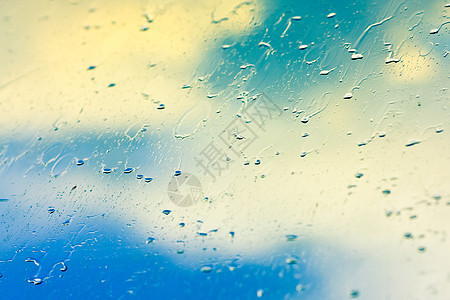 雨后在玻璃上滴水白色环境日光水滴波纹多云窗户天空宏观流动图片