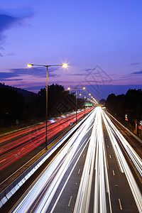 夜间在高速公路上交通日落车辆路线旅行车道驾驶速度指标大灯辉光图片