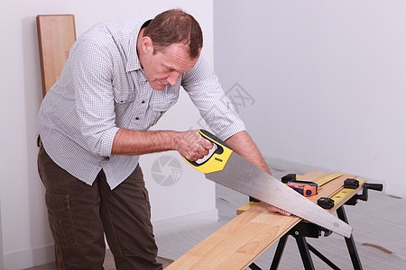男子锯木地板图片