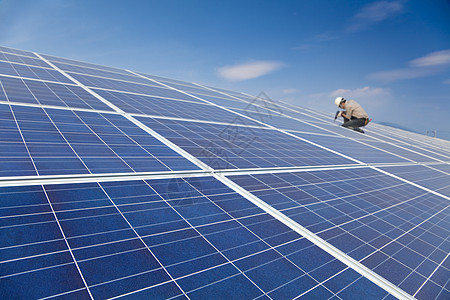 特写太阳能电池板和安装光伏太阳能电池板的专业工人图片