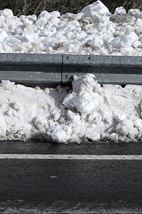 在公路沥青路边钢铁围栏上的雪雪图片