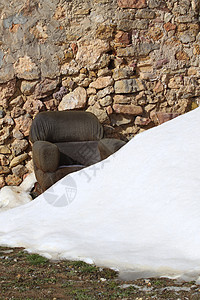 雪地石砖墙上的椅子图片