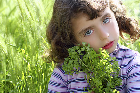 小女孩拥抱绿色植物草地的尖刺图片