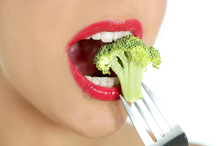 女人嘴中钢叉上的花椰子牙齿口红微笑女士化妆品宏观蔬菜女孩饮食沙拉图片