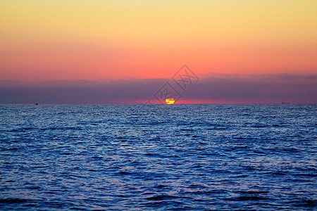 蓝海日出 地平线中阳光照耀晴天戏剧性云景太阳风景海洋反射海景日落天气图片