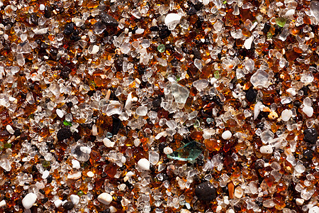 特写沙滩上的玻璃碎片海岸粮食瓶子鹅卵石辉光支撑海洋沿海风化海滩图片