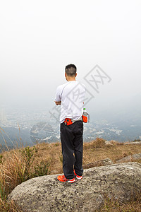 亚洲人在山上徒步旅行蓝色季节冒险团体石头顶峰远足者男人天空运动图片