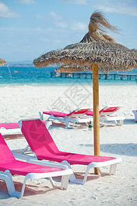 沙滩上的椅子和雨伞极乐休息屁股天堂支撑玩弄海滩海岸面包热带图片