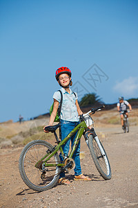 少女骑着自行车看风景 坐着自行车青少年头盔乐趣女性山地孩子们孩子女孩场地喜悦图片