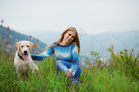 女孩带着她的狗女性山脉宠物猎犬场景乐趣草地友谊女士朋友图片