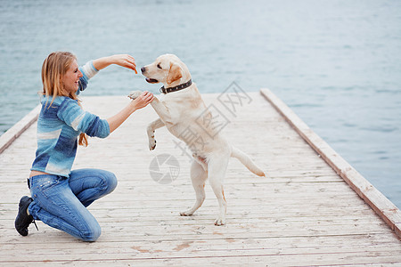 带狗的女孩闲暇宠物猎犬行动乐趣朋友草地拥抱女士蓝色图片