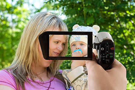 快乐的妈妈和儿子生活女性相机电影微笑技术展示视频家庭屏幕图片