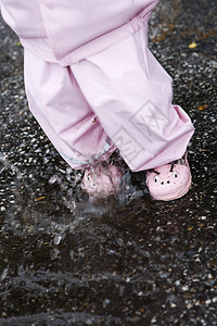 户外女婴运动童年雨水外套快乐俏皮跳跃飞溅小女孩跳高图片